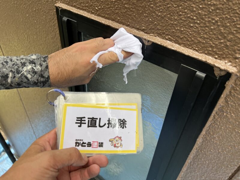 手直し掃除の様子です。養生を貼っていたテープから漏れた塗料を、溶解力の弱いシンナーを使いサッシを傷つけないよう慎重に掃除します。