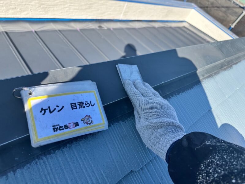 屋根の棟板金のケレンの様子です。サンドペーパーなどで表面の汚れを落とし、塗料の密着性を高めます。