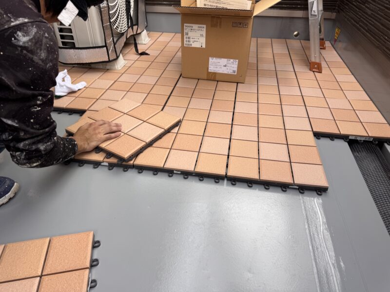 防水面保護のため、バルコニー床にフロアタイルを敷いていきます。