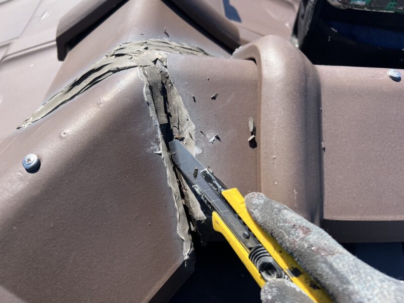 棟瓦の既存のコーキングを撤去していきます。