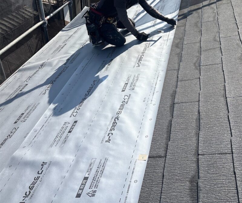 屋根カバー工法で施工します。<br />
既存の屋根材の上に防水紙を貼っていきます。