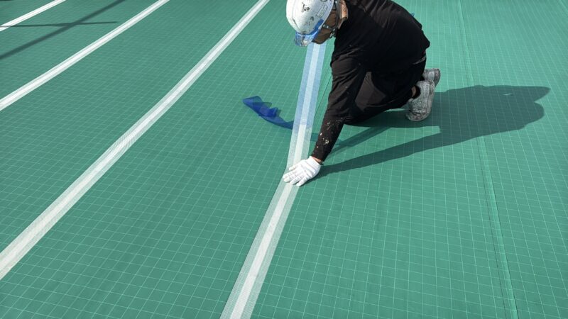 シートの継ぎ目を100ｍｍ幅のテープで隙間ができないよう丁寧に貼っていきます。